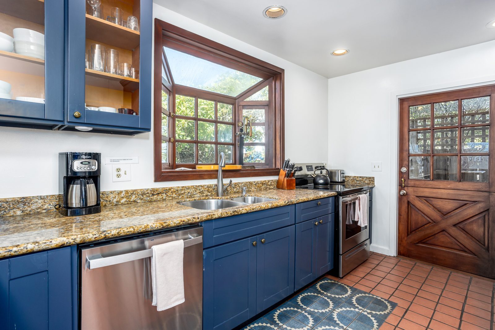 Kitchen with garden window and blue cabinetry
