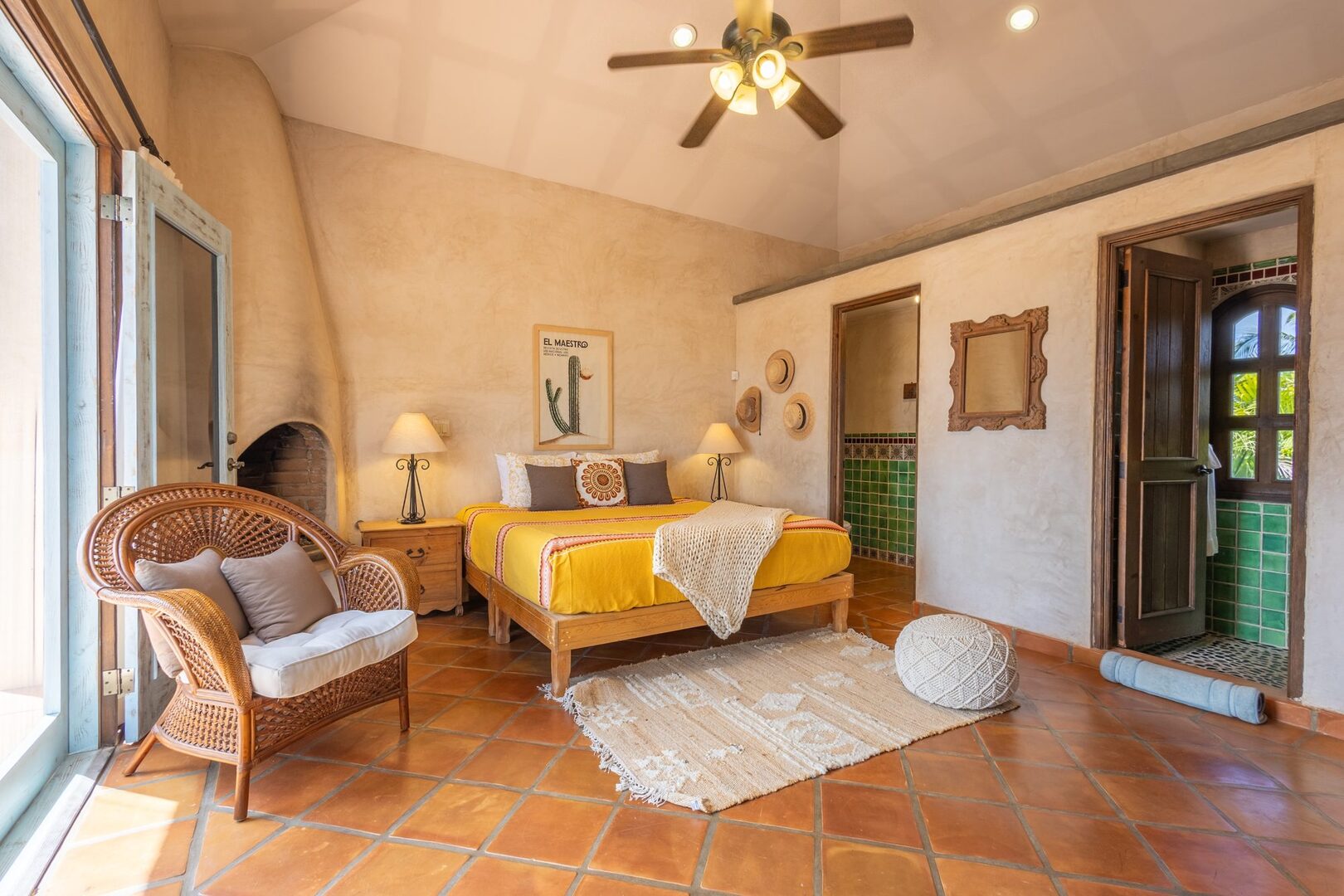 Artist Refuge bedroom with fireplace, wicker chair, and en-suite bathroom