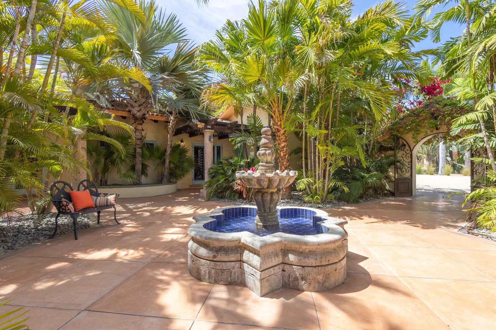 Courtyard stone fountain surrounded by palms