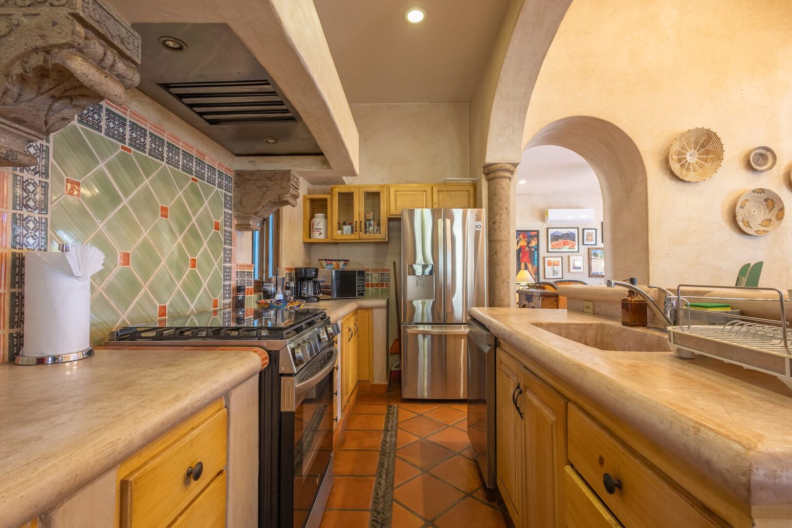 Full galley kitchen with stainless appliances and Talavera tile backsplash