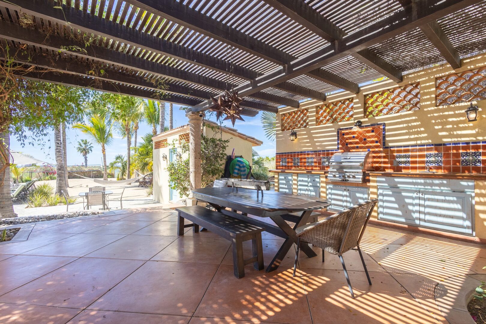 Outdoor kitchen and dining area under the pergola