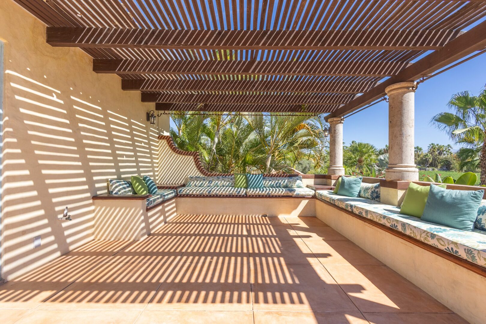Pergola-shaded lounge seating overlooking the farm fields